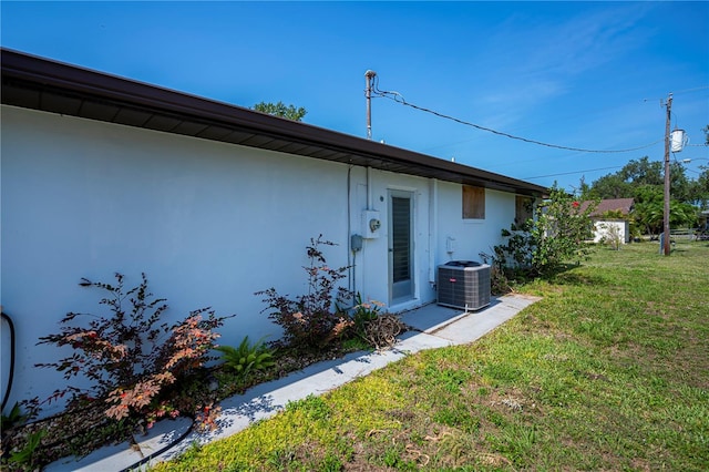 2113 Barksdale St, Port Charlotte, FL 33948 - rear view of house featuring central AC, a lawn, and stucco siding