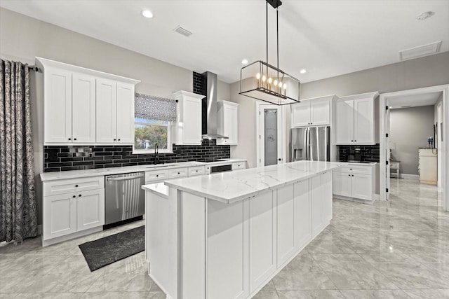 kitchen featuring marble finish floor, a kitchen island, wall chimney exhaust hood, a sink, and stainless steel appliances