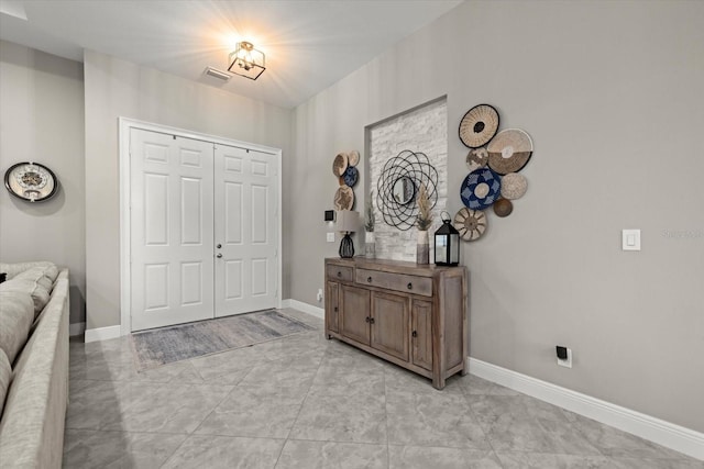 foyer entrance featuring baseboards and visible vents