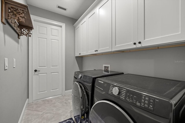 laundry room with baseboards, visible vents, cabinet space, and washer and clothes dryer