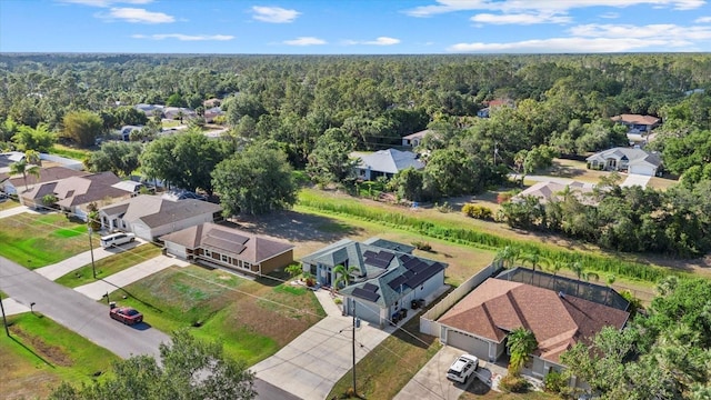 drone / aerial view featuring a residential view and a forest view
