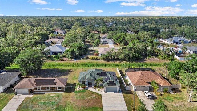 drone / aerial view with a wooded view and a residential view