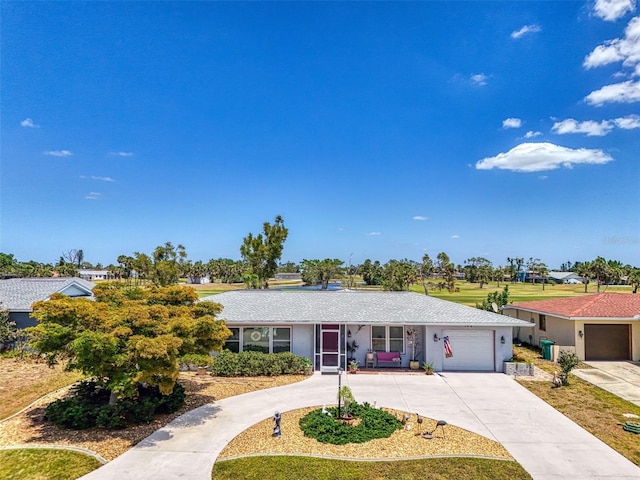 ranch-style home featuring an attached garage, driveway, and stucco siding