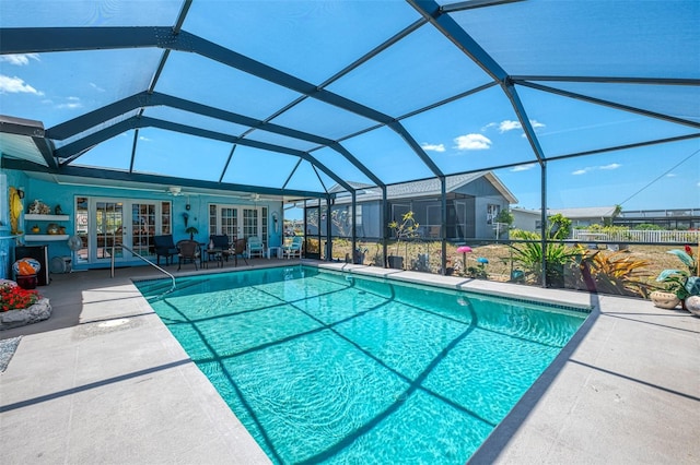 outdoor pool with french doors, a lanai, ceiling fan, and a patio area