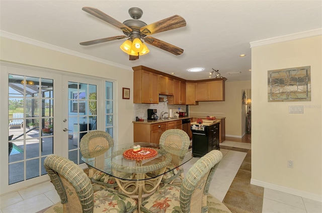 dining space with baseboards, ornamental molding, and light tile patterned flooring