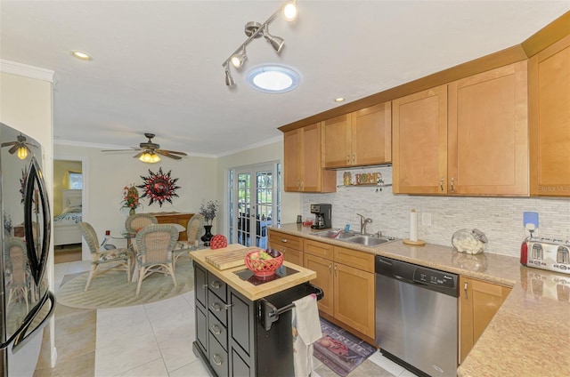 kitchen featuring crown molding, a sink, dishwasher, light countertops, and freestanding refrigerator