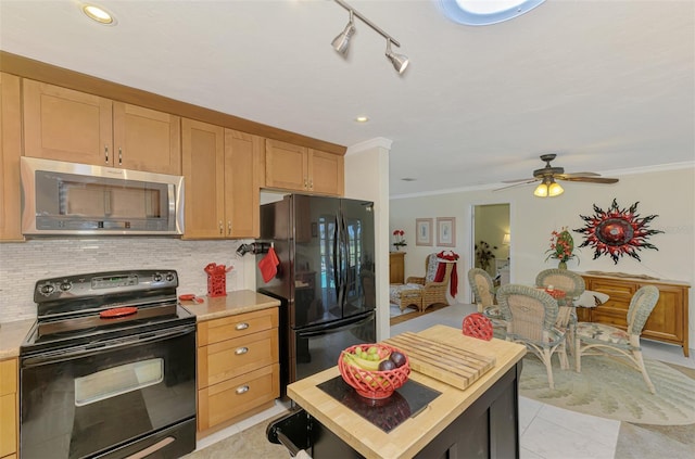 kitchen with crown molding, light countertops, backsplash, and black appliances