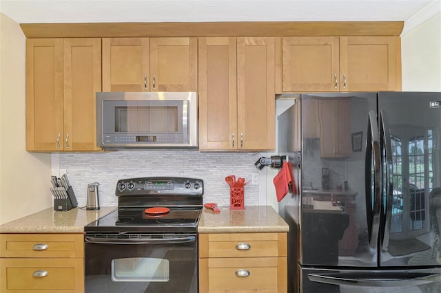 kitchen with light stone counters, decorative backsplash, and black appliances