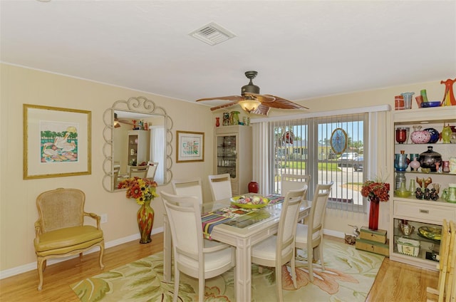 dining space with visible vents, light wood-style floors, ceiling fan, and baseboards