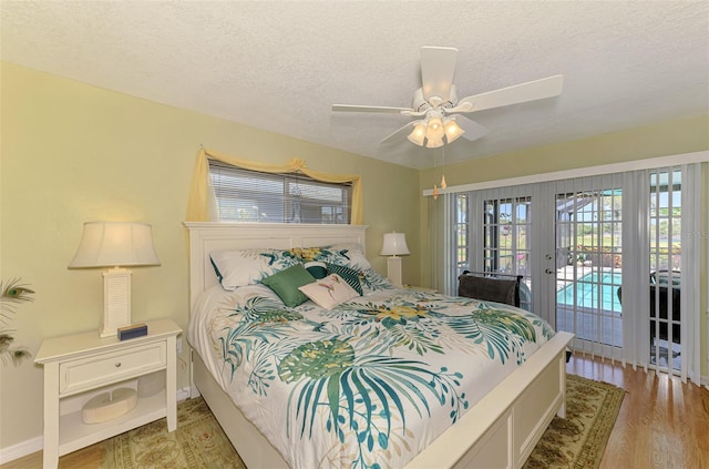 bedroom featuring access to exterior, light wood-style floors, a textured ceiling, french doors, and a ceiling fan