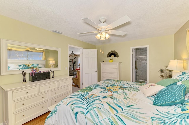 bedroom with ensuite bathroom, a ceiling fan, a textured ceiling, and visible vents