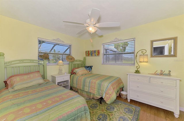 bedroom with baseboards, ceiling fan, and wood finished floors