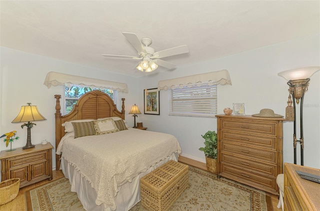 bedroom with light wood-style floors, baseboards, and ceiling fan