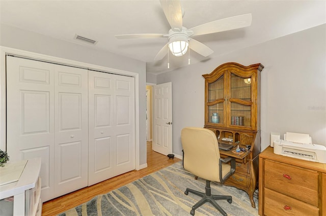 office area with ceiling fan, light wood-style flooring, and visible vents
