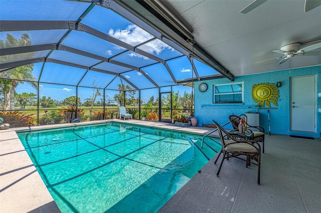 pool featuring a ceiling fan, glass enclosure, and a patio area