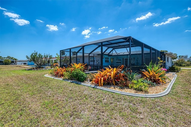 rear view of property with a lanai and a yard