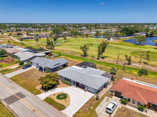 drone / aerial view with a water view, golf course view, and a residential view