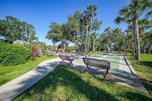 view of property's community with a yard and shuffleboard