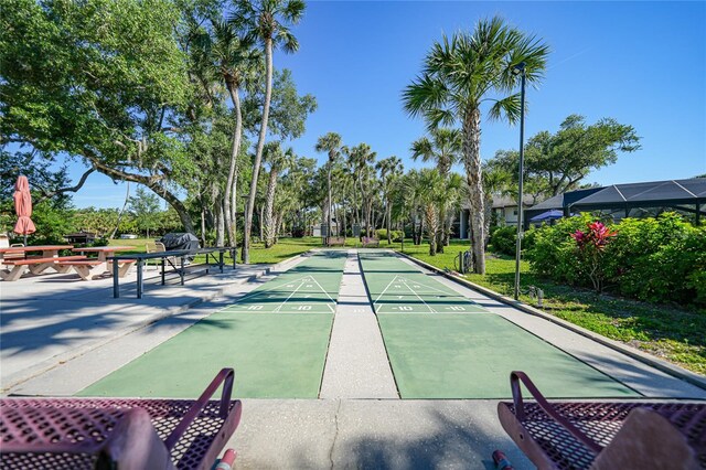view of property's community featuring a yard and shuffleboard