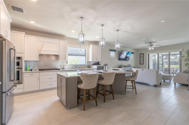 6763 Winding Cypress Dr, Naples, FL 34114 - kitchen featuring appliances with stainless steel finishes, open floor plan, visible vents, and a healthy amount of sunlight
