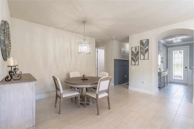 6763 Winding Cypress Dr, Naples, FL 34114 - dining room featuring arched walkways, baseboards, and a chandelier