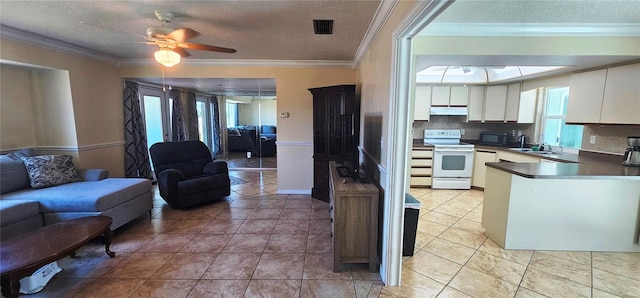 570 Mimosa Ave NW, Port Charlotte, FL 33952 - kitchen with white electric stove, open floor plan, black microwave, healthy amount of natural light, and a textured ceiling