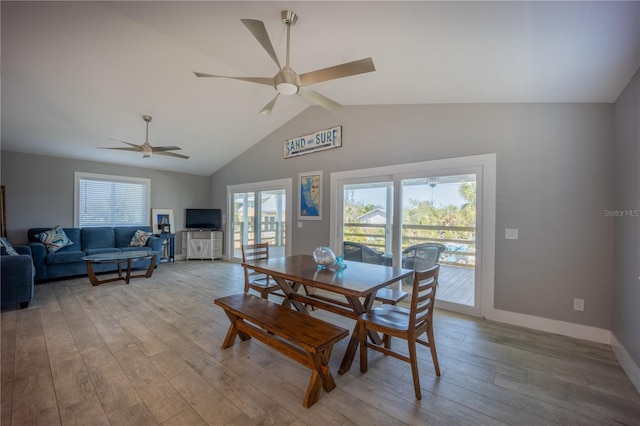 dining space featuring a wealth of natural light, vaulted ceiling, wood finished floors, and a ceiling fan