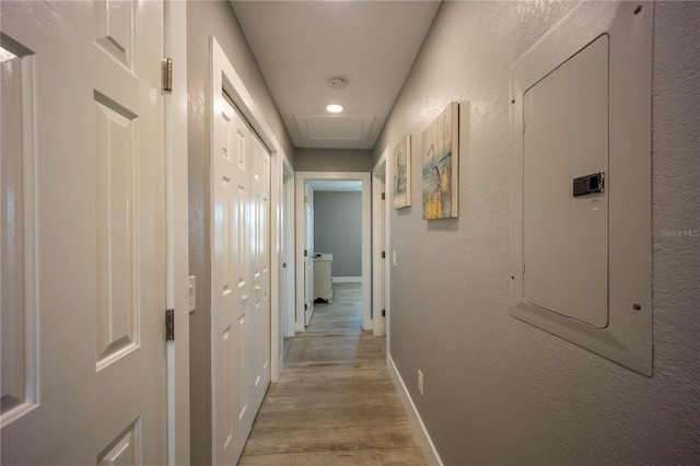 hall with light wood-style flooring and baseboards