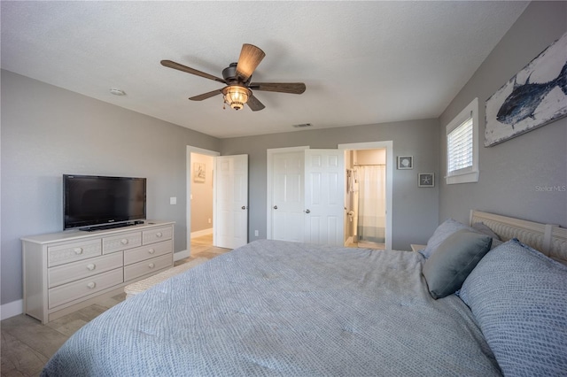bedroom featuring connected bathroom, a ceiling fan, light wood-type flooring, visible vents, and baseboards