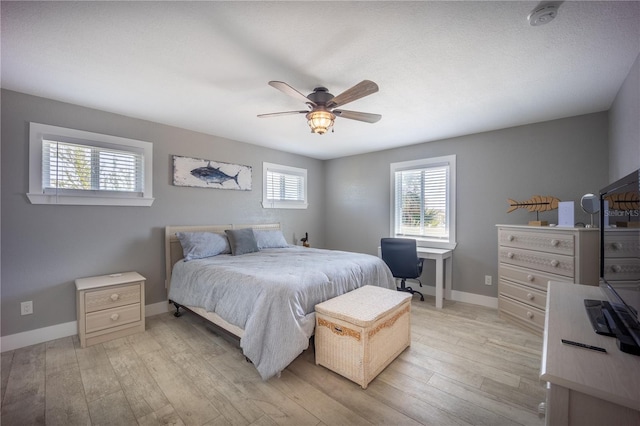bedroom featuring ceiling fan, baseboards, and light wood-style floors