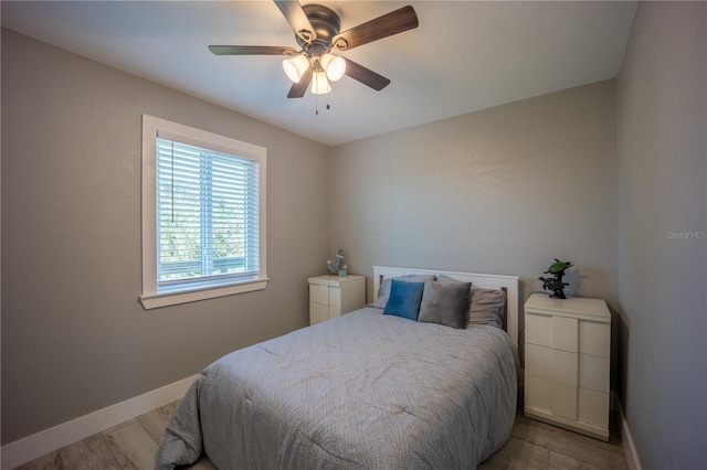 bedroom with wood finished floors, baseboards, and a ceiling fan