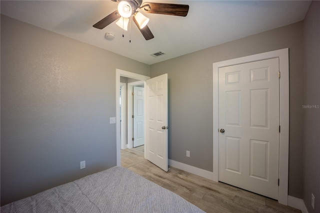 unfurnished bedroom with light wood-type flooring, visible vents, baseboards, and ceiling fan