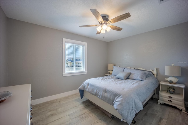 bedroom featuring wood-type flooring, baseboards, and a ceiling fan