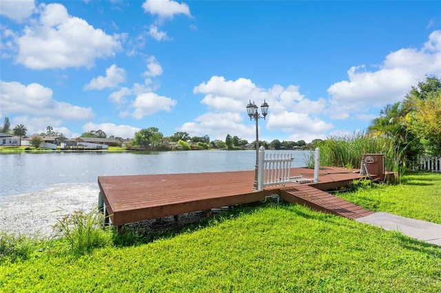 dock area featuring a lawn and a water view
