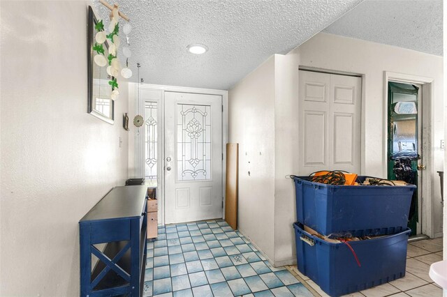 entrance foyer featuring light tile patterned floors and a textured ceiling