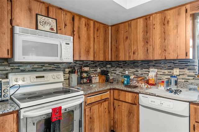 kitchen featuring brown cabinets, backsplash, and white appliances