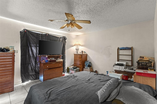 tiled bedroom featuring ceiling fan and a textured ceiling