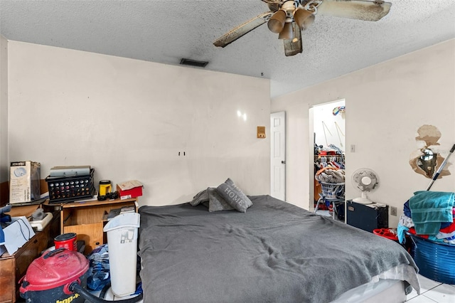 bedroom with visible vents, a ceiling fan, and a textured ceiling