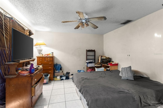 bedroom featuring a ceiling fan, light tile patterned flooring, a textured ceiling, and visible vents