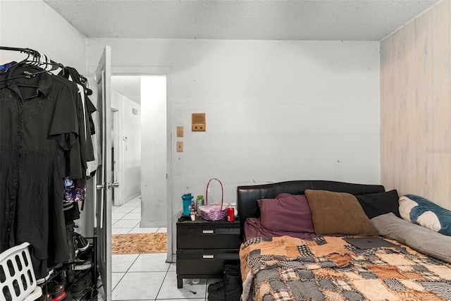 bedroom featuring light tile patterned floors and a textured ceiling