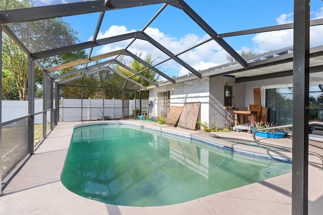 view of swimming pool with a fenced in pool, a fenced backyard, glass enclosure, and a patio