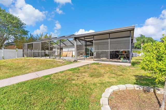 rear view of property with fence, a pool, a patio area, a lanai, and a yard
