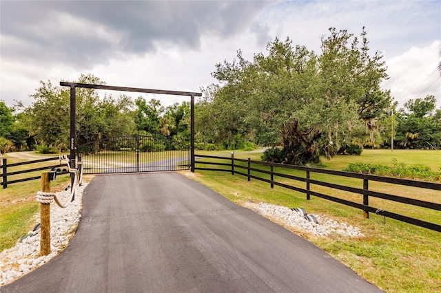 view of road with driveway, a gated entry, and a gate
