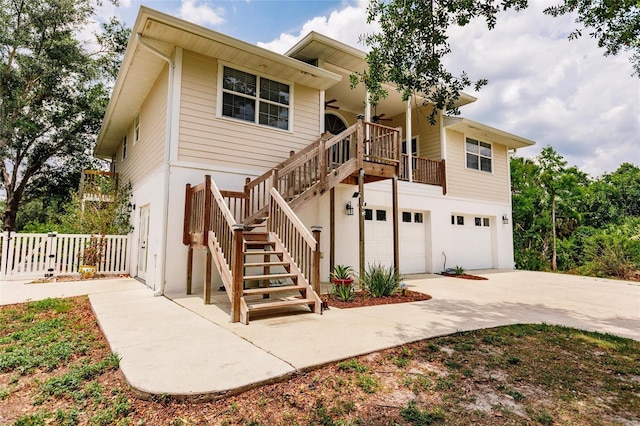 view of front of house with a garage, fence, stairs, and driveway