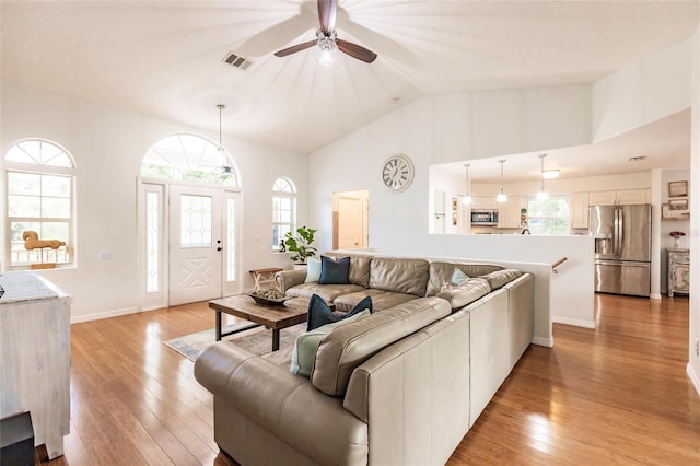 living room with light wood-style flooring, ceiling fan, and a wealth of natural light