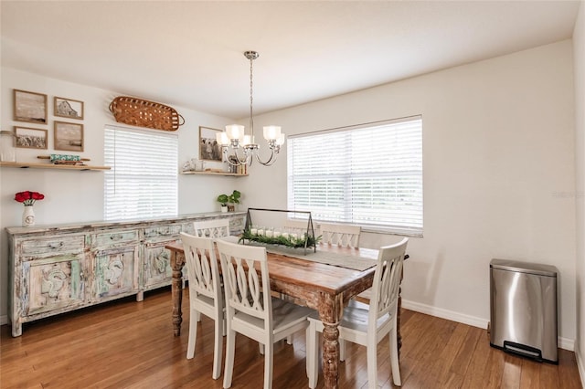 dining room with an inviting chandelier, baseboards, and wood finished floors
