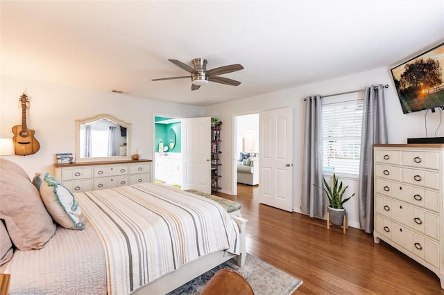 bedroom with ceiling fan, multiple windows, wood finished floors, and visible vents