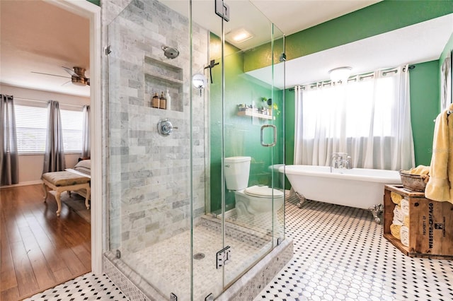full bath featuring ceiling fan, a freestanding bath, and a stall shower
