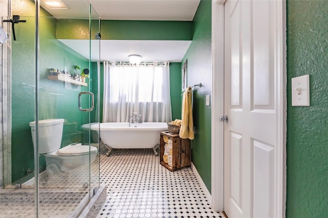 bathroom with a textured wall, toilet, tile patterned floors, a shower stall, and a soaking tub