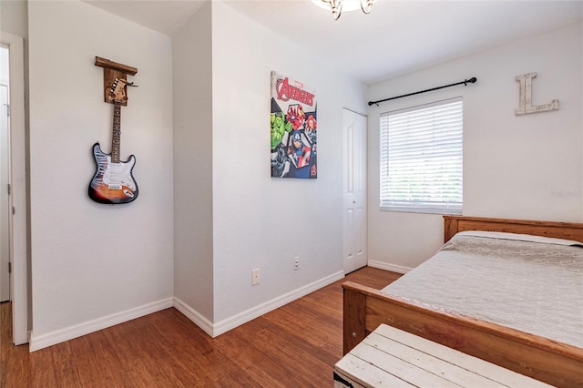 bedroom with baseboards, a closet, and wood finished floors